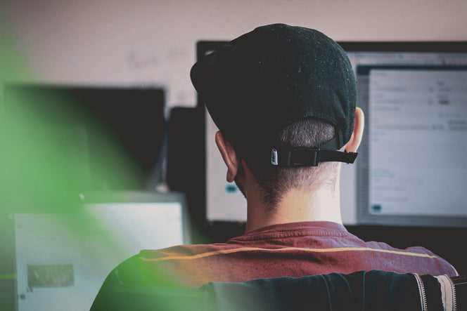 Graphic designer sitting in front of two monitors working 